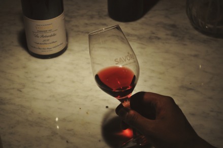 Step 1: Right after pouring the wine into your glass, tilt it slightly with your rist to analyze the opacity and pigmentation of the wine. Visual analysis will teach you a lot about what kind of wine it is. Bordeaux wines, for example, will be much darker and much more opaque than Beaujolais.